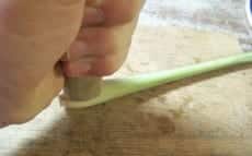 On écrase les tiges de citronnelle avec le manche d'in couteau pour qu'elles expriment mieux leurs saveurs